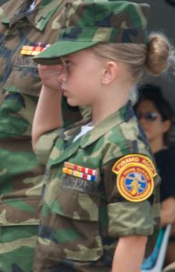 Photo of a member of the Young Marines salutes to honor America's war dead at the 2017 observance. Copyright, Greg Concilla, 2017